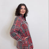Woman wearing a red and black plaid shirt against a white background