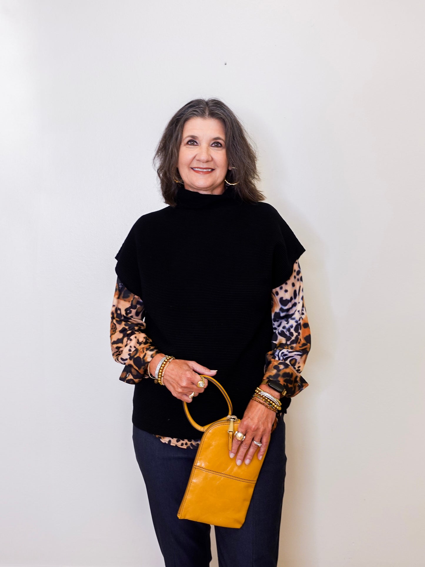 Woman holding a yellow handbag against a white background