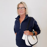 Woman wearing a navy blue pullover with a white background