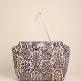 Patterned tote bag with white handles on a beige background