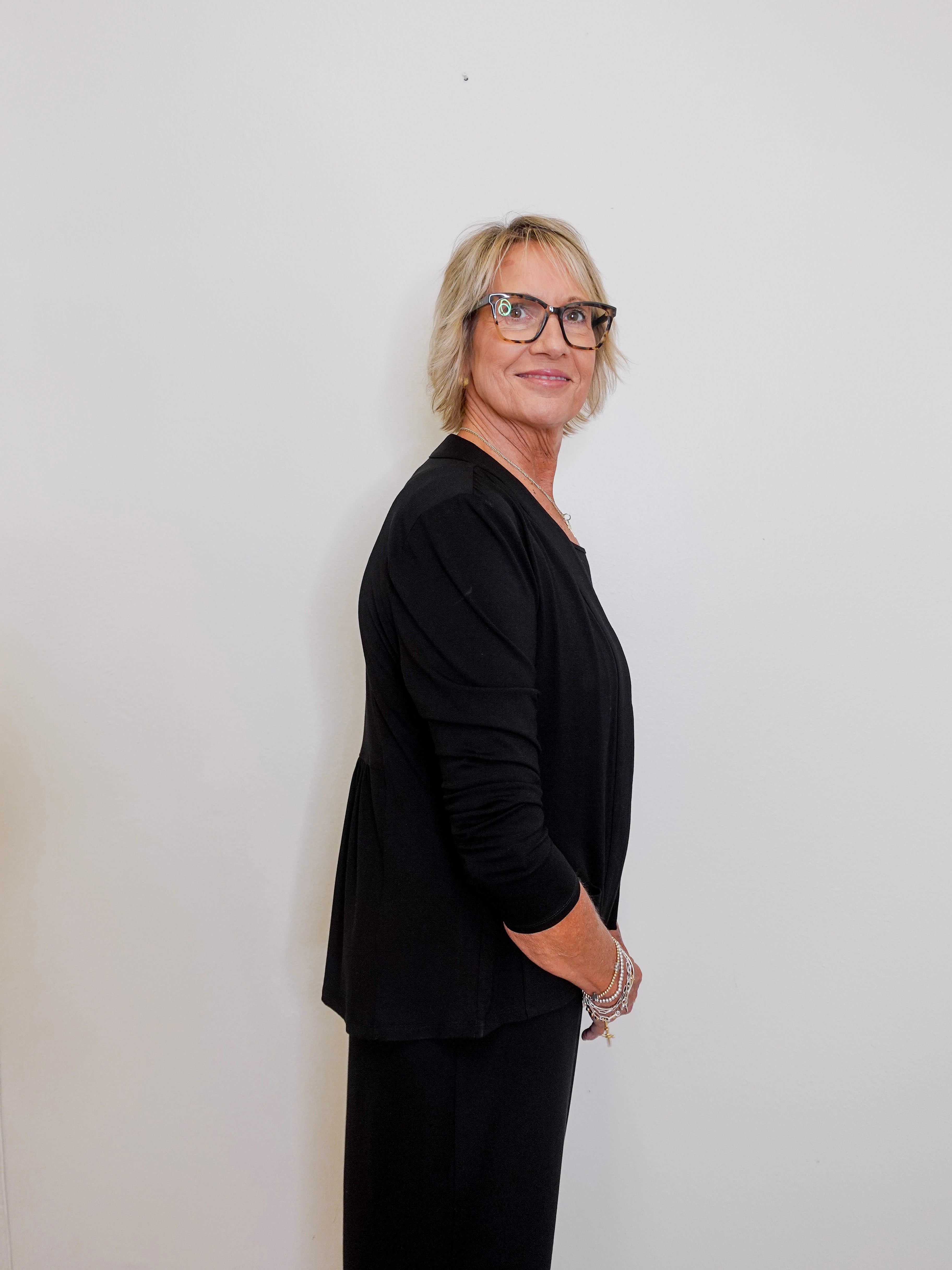 Person wearing a black outfit against a plain background