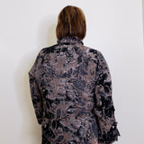 Person wearing a floral patterned blouse against a white background