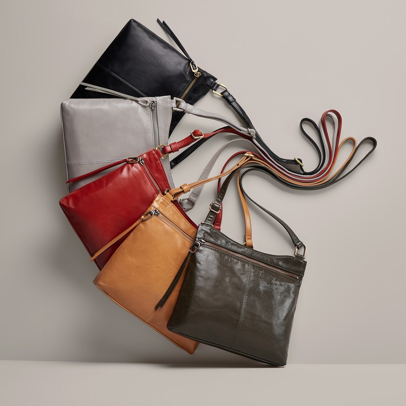 Collection of leather handbags in various colors on a neutral background