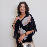 Woman holding a metallic handbag against a plain background