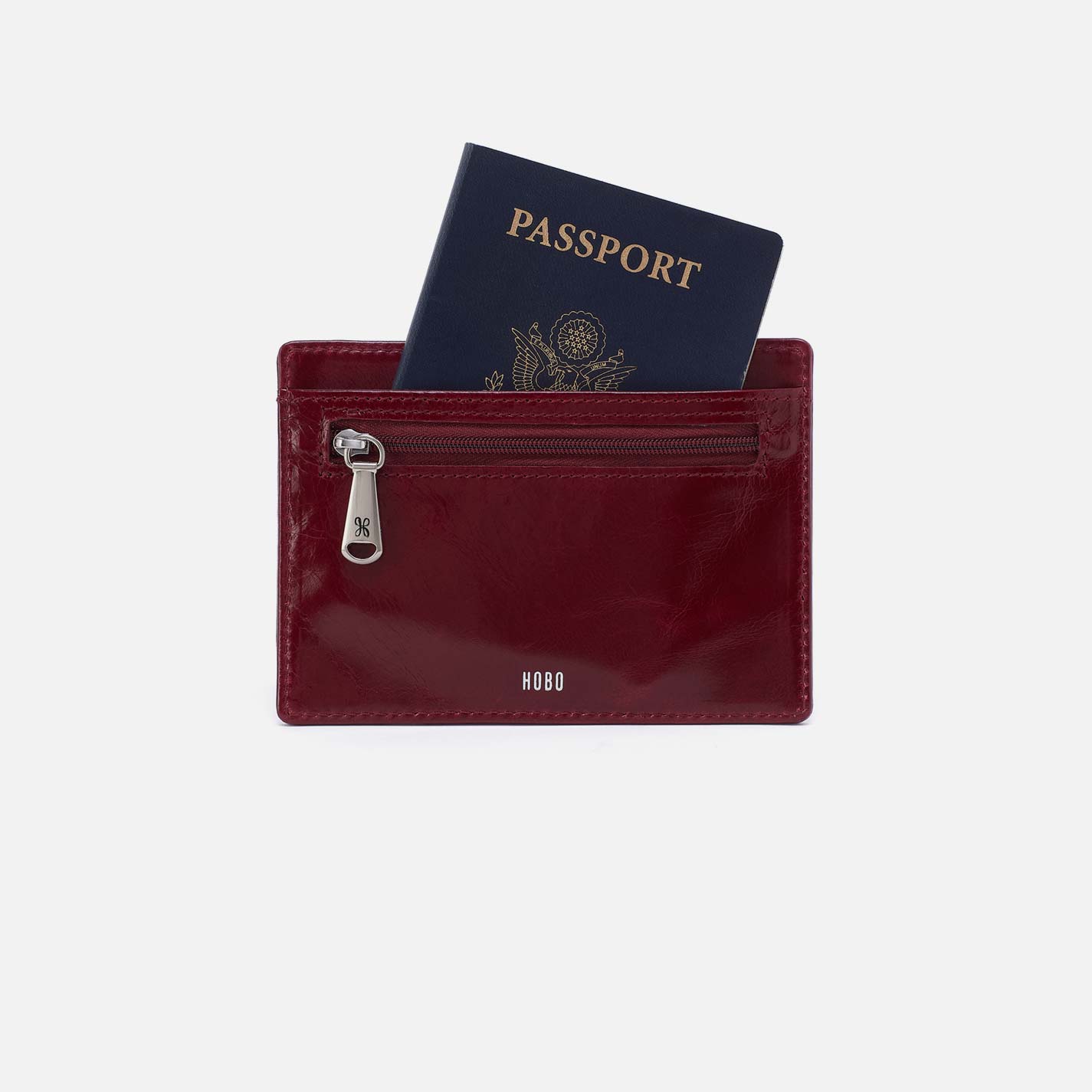 Maroon wallet with a passport inside on a light gray background