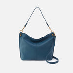 Blue handbag with a strap on a light gray background