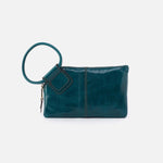 Teal leather clutch bag with a round handle on a white background