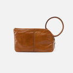 Brown leather clutch with a circular handle on a white background