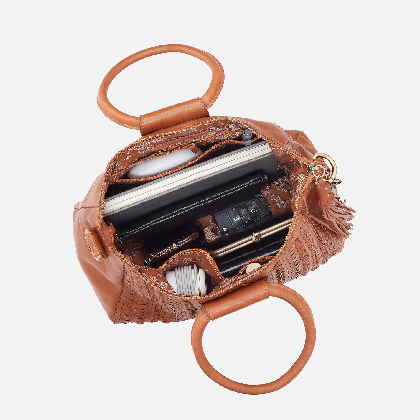 Brown leather handbag with handles open, showing its interior on a white background