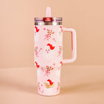 Pink tumbler with red bird design on a beige background