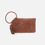 Brown suede clutch with ring handle and tassel on a white background