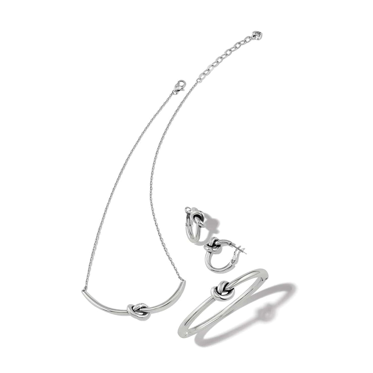 Silver necklace, bracelet, and ring set on a white background