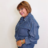 Woman wearing a denim jacket and jeans against a white background