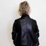 Person wearing a black leather jacket against a white background