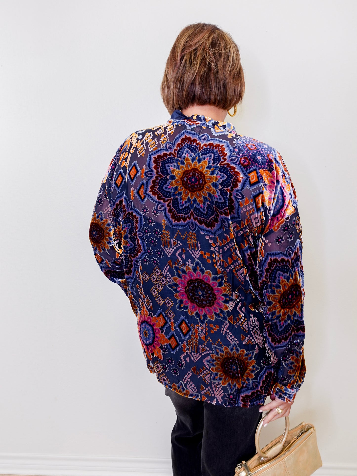 Person wearing a colorful patterned shirt against a white background