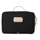 Black toiletry bag with beige handle and patch on a white background