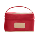 Red cosmetic bag with beige handle and patch on a black background