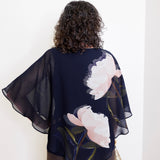 Woman wearing a dark blue floral kimono against a white background
