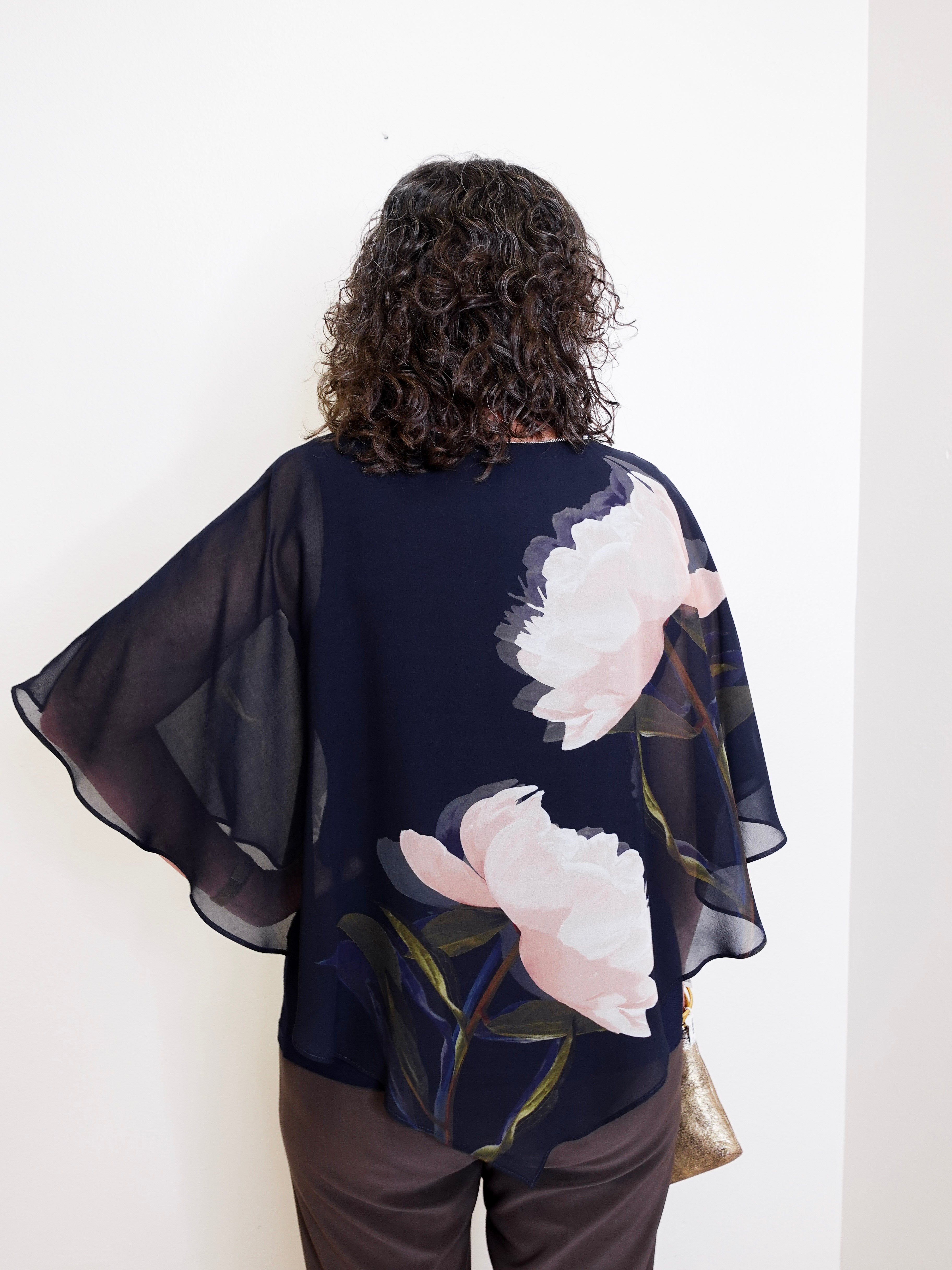 Woman wearing a dark blue floral kimono against a white background
