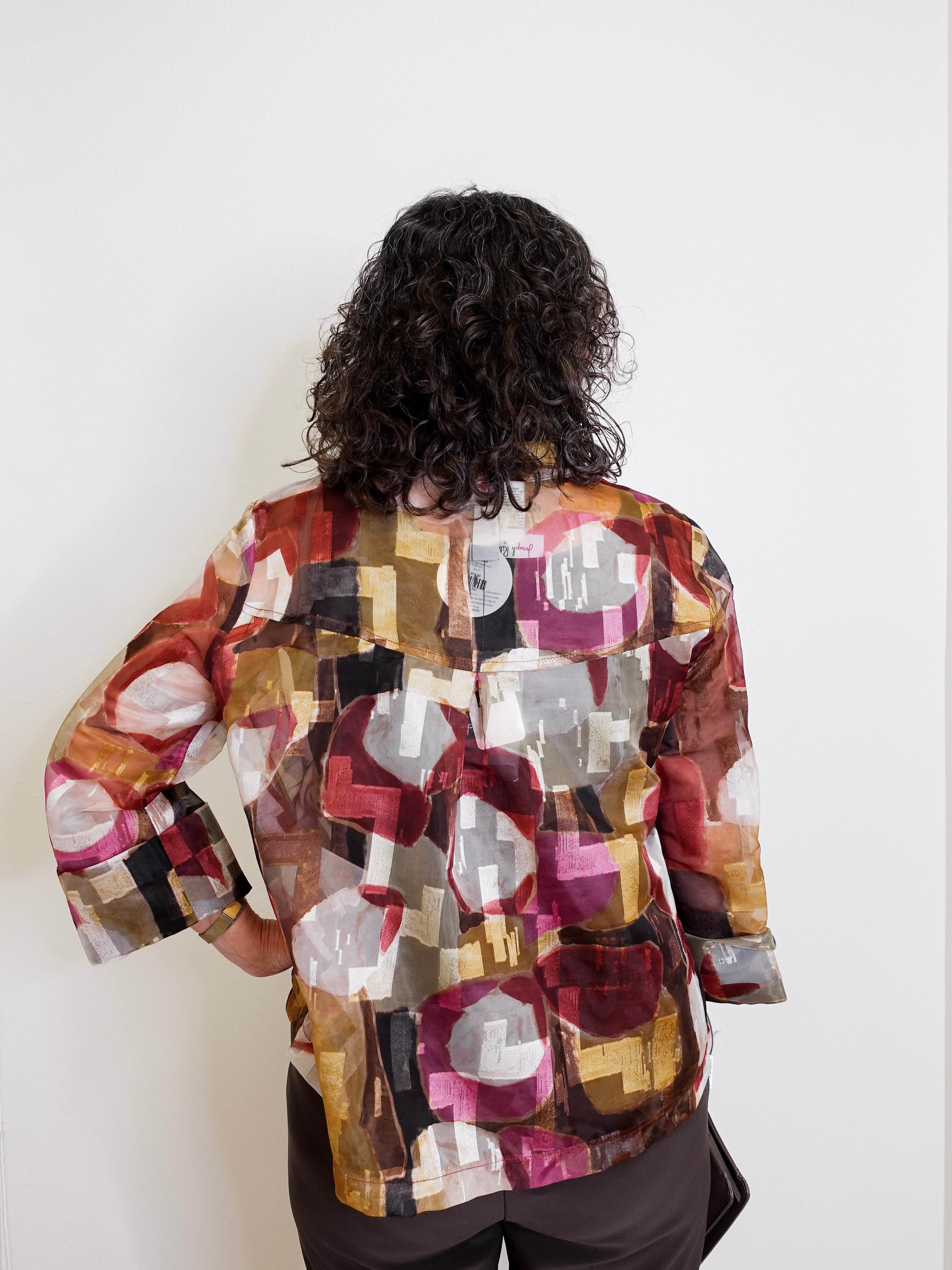 Person wearing a colorful patterned jacket against a white background