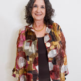 Woman wearing a colorful patterned jacket against a white background
