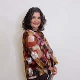 Woman wearing a patterned blouse against a white background
