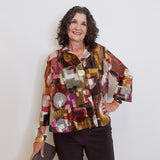 Woman wearing a colorful patterned jacket against a white background