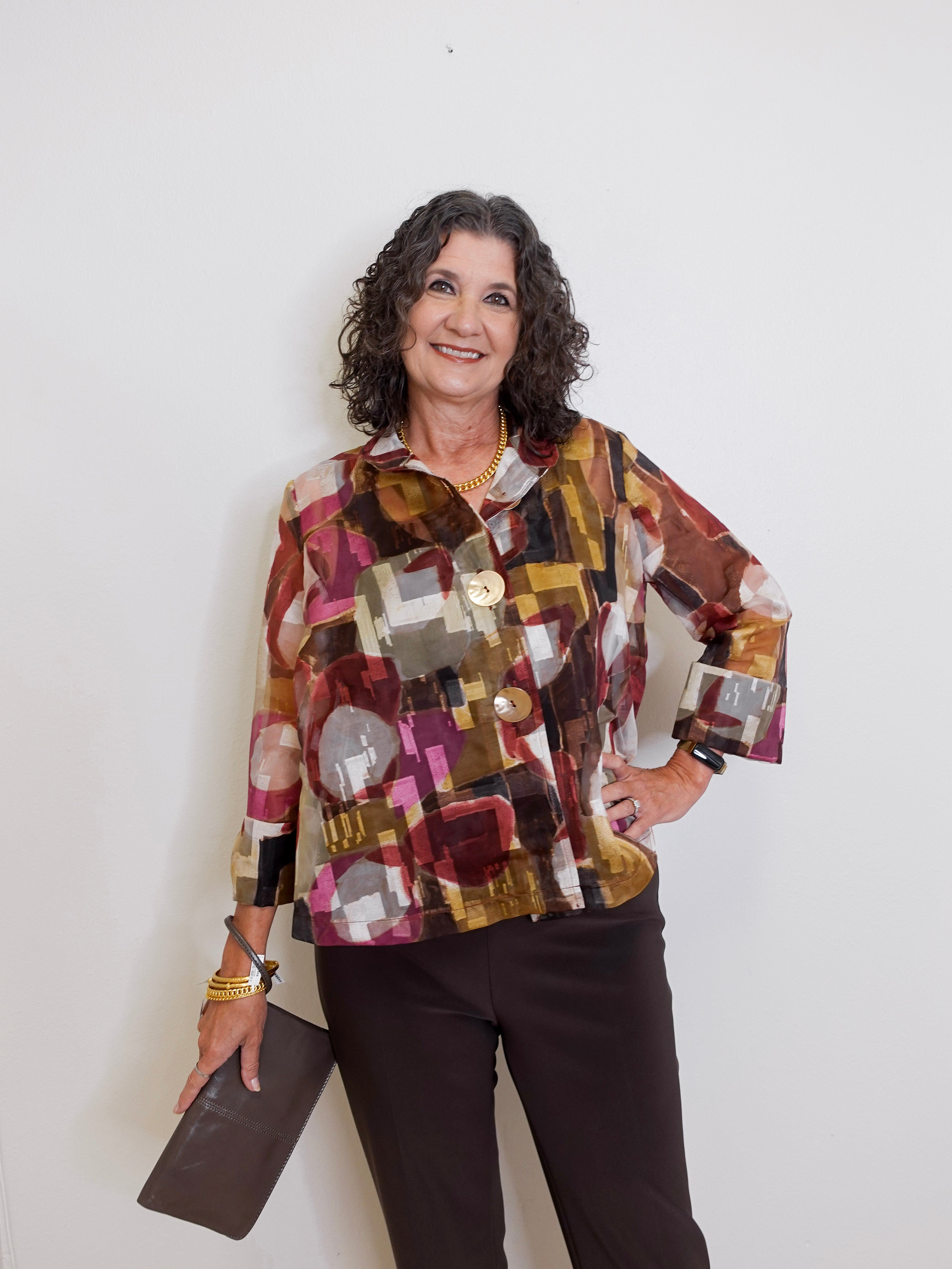 Woman wearing a colorful patterned jacket against a white background