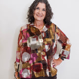 Woman wearing a patterned shirt against a plain background