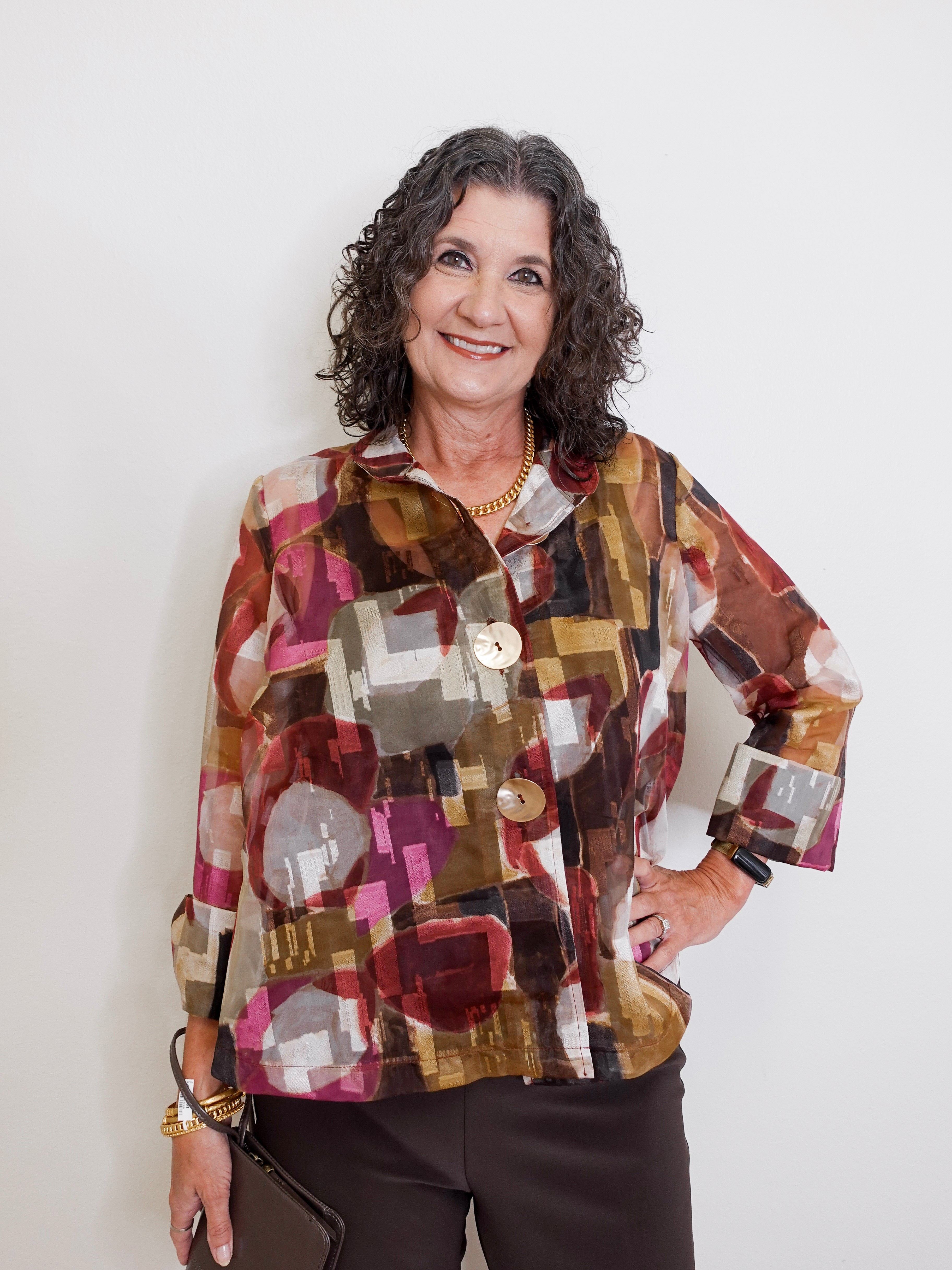 Woman wearing a patterned shirt against a plain background