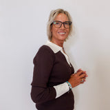 Woman wearing a brown and white sweater against a plain background