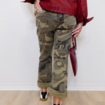 Person wearing a red jacket and camouflage pants on a white background