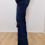 Person wearing blue jeans with a white wall background
