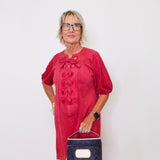 Woman wearing a red dress with puff sleeves against a white background