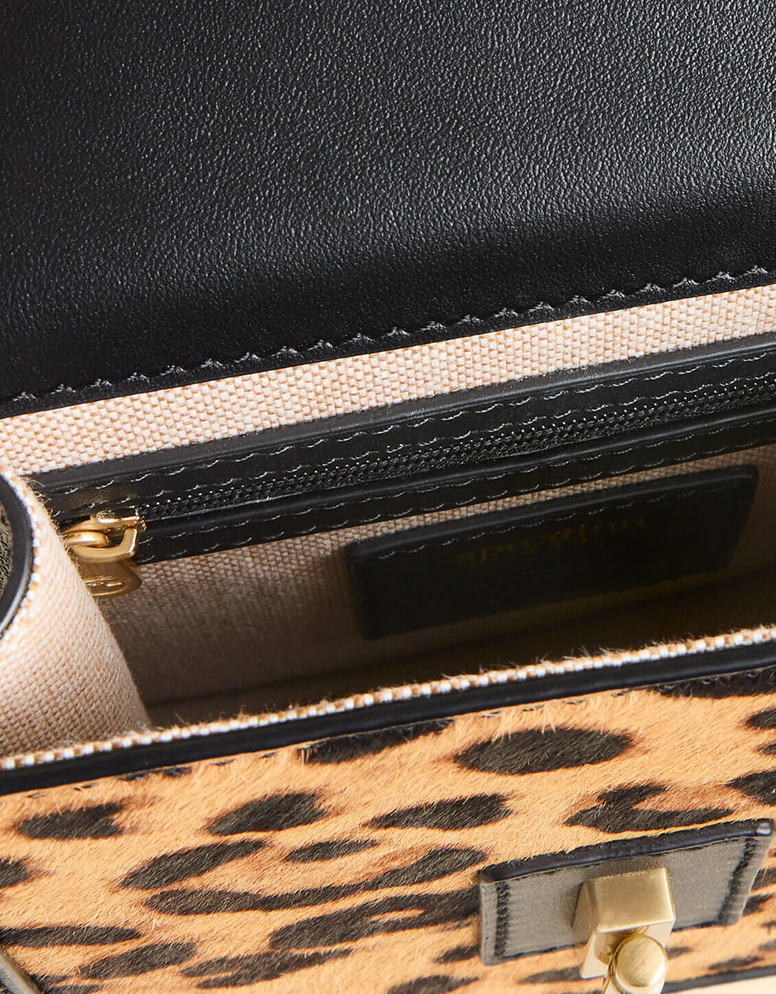 Close-up of a handbag with leopard print and black leather accents.