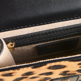 Close-up of a handbag with leopard print and black leather accents.