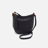 Black leather handbag with a strap on a light gray background