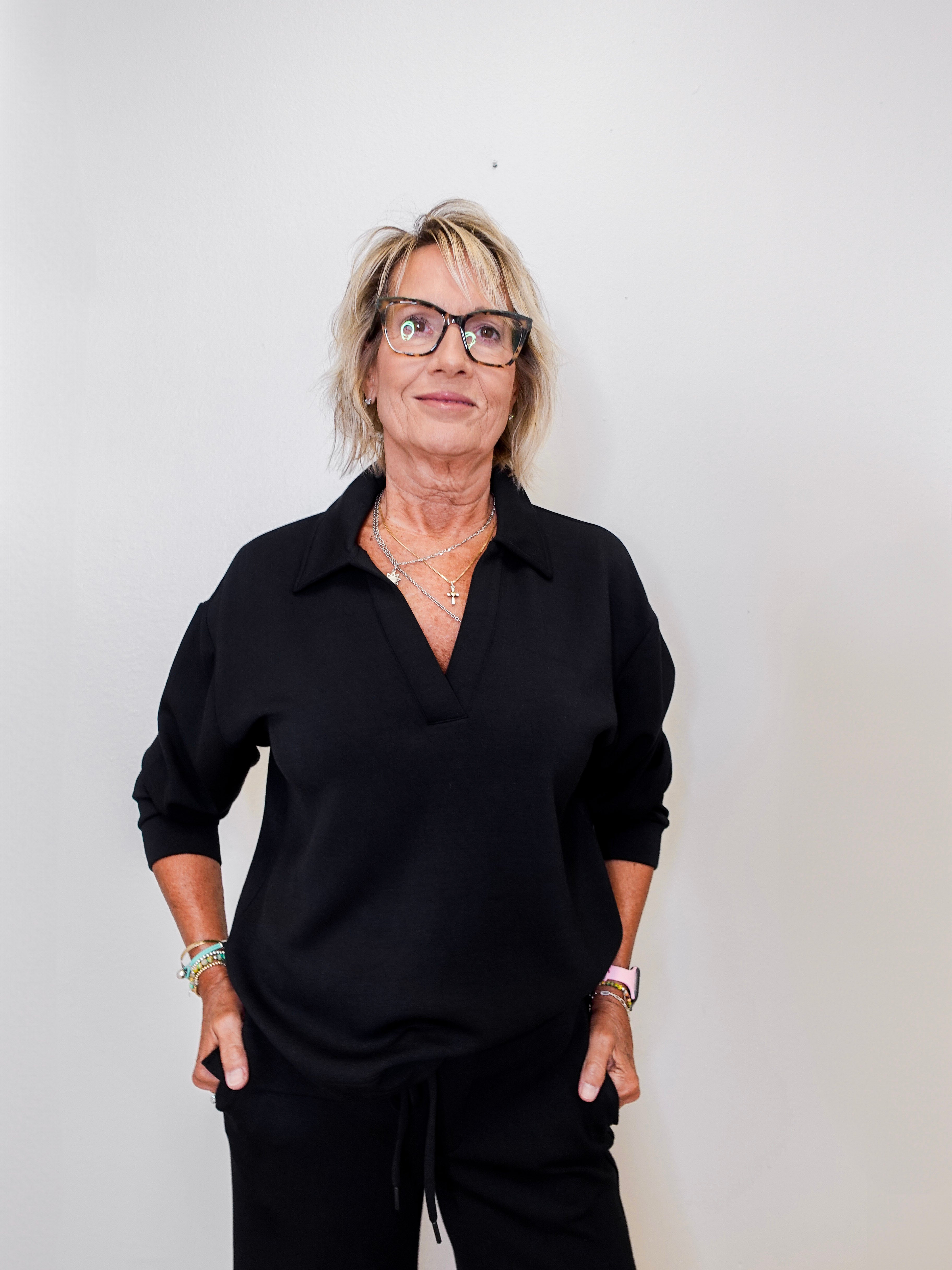 women modeling a black v neck sweatshirt against a white background