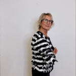 Person wearing a black and white striped shirt against a plain background