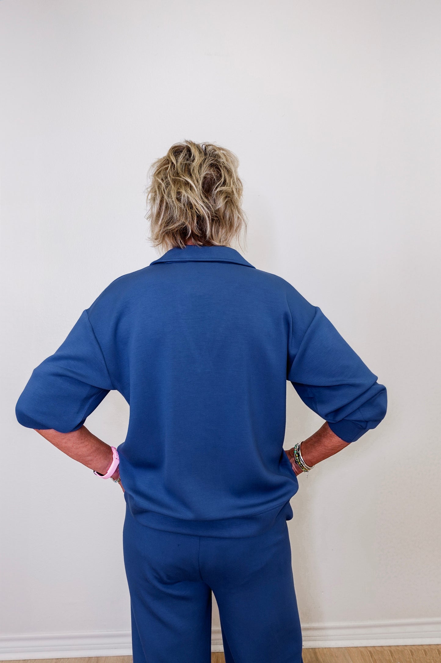 Model showcasing Liverpool pacific blue collar V-neck popover sweatshirt in front of white wall