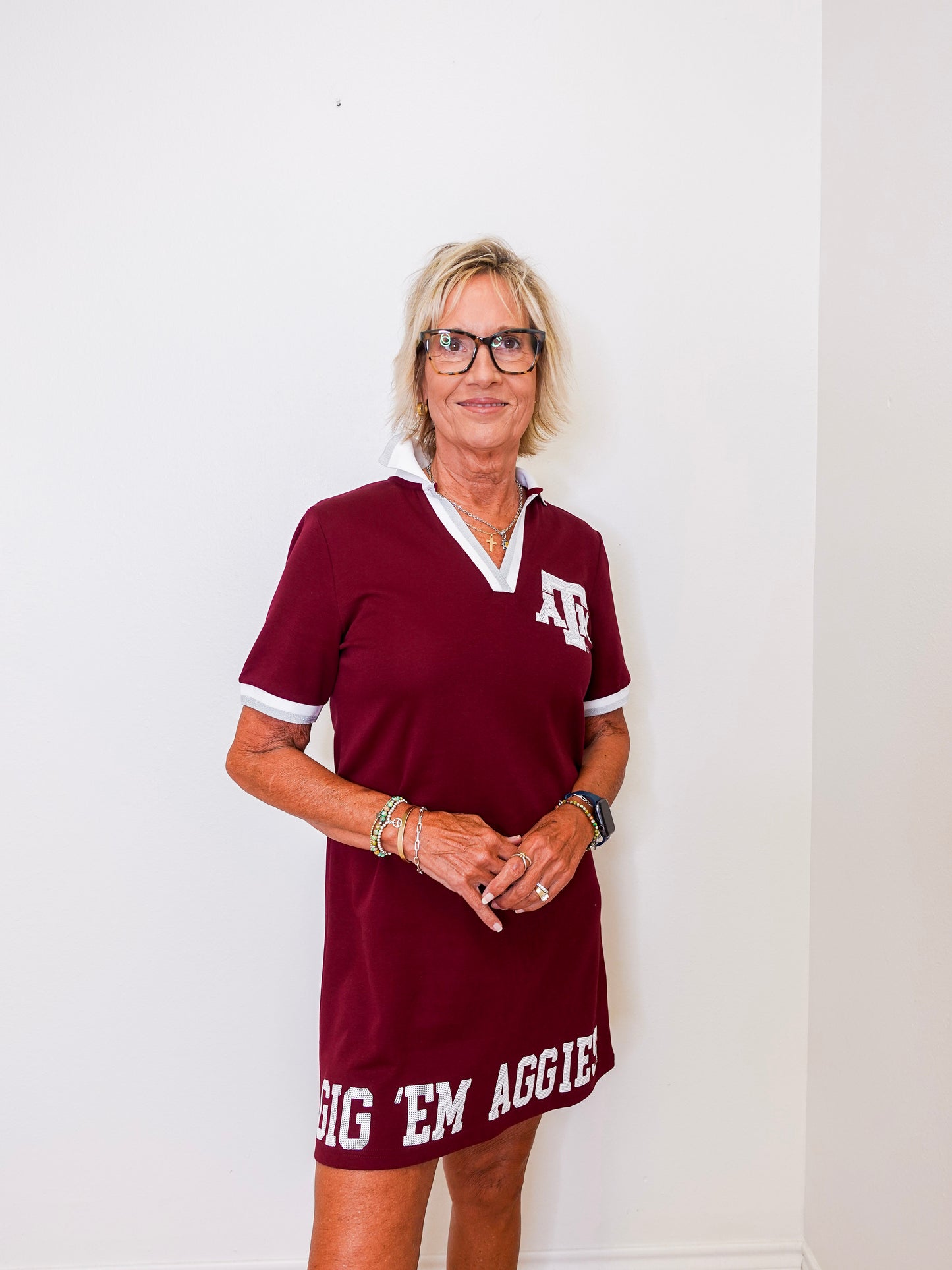 Woman wearing a maroon dress with 'Big 'Em Aggies' text against a white background