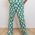 Person wearing a green patterned outfit on a plain background