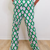 Person wearing a green patterned outfit on a plain background