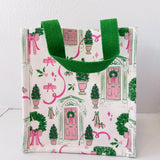Small tote bag with festive design featuring green trees, pink ribbons, and wreaths on a white background.