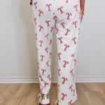 Person wearing a white outfit with red floral patterns on a wooden floor.