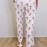 Person wearing a white outfit with red floral patterns on a wooden floor.