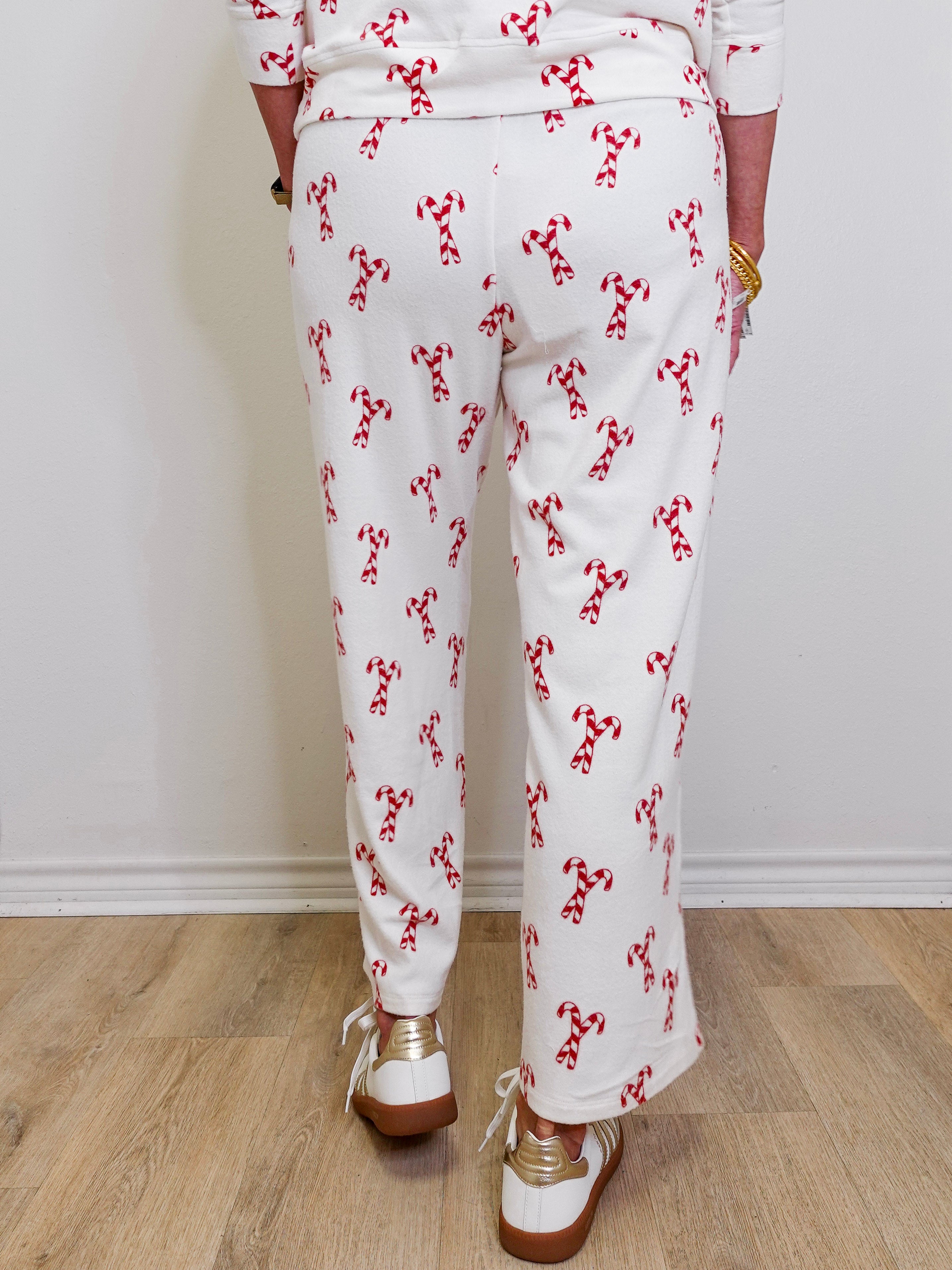 Person wearing a white outfit with red floral patterns on a wooden floor.