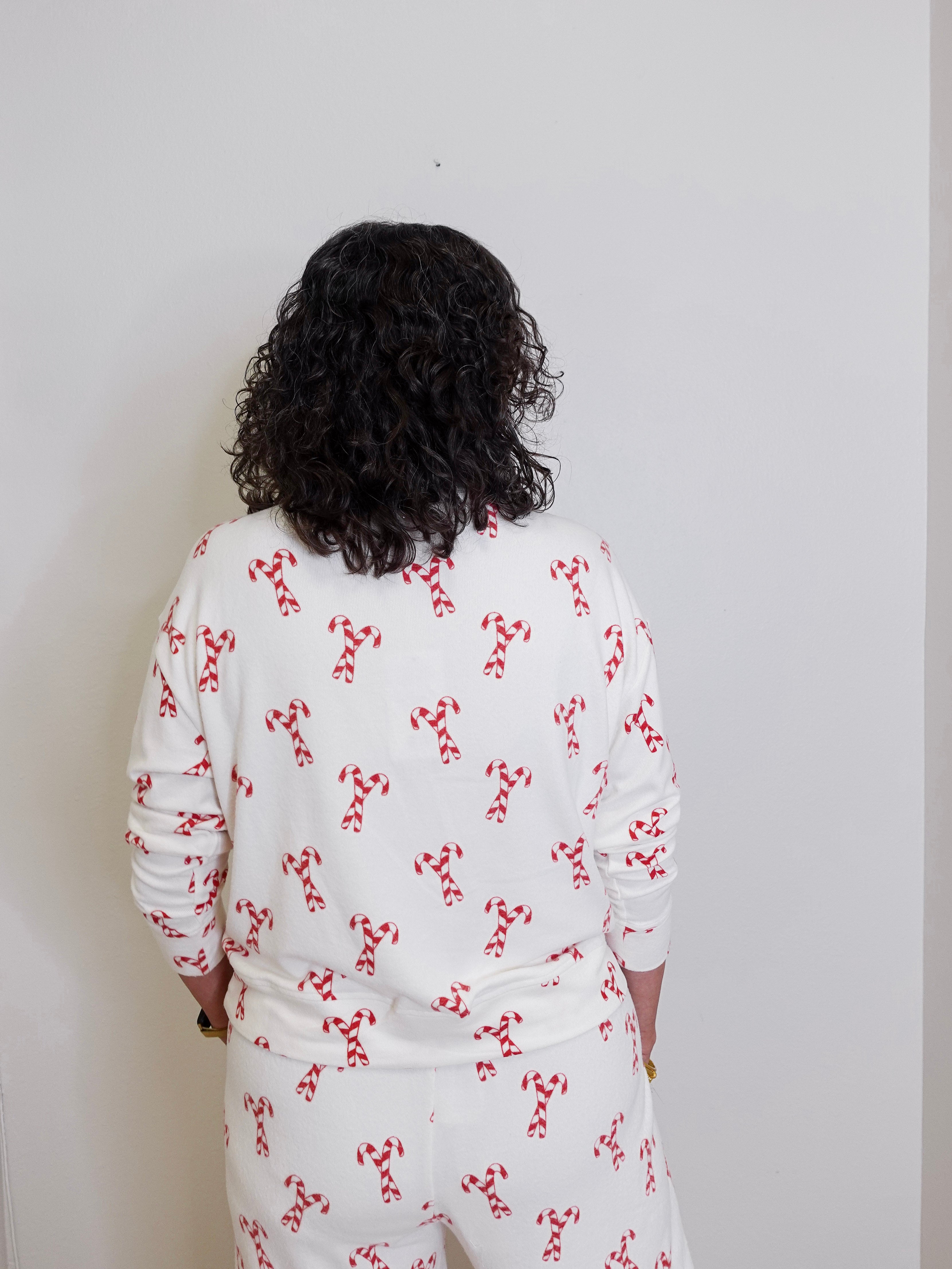 Person wearing a white outfit with red patterns against a plain background