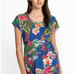 Woman wearing a colorful tropical floral pajamas on a white background