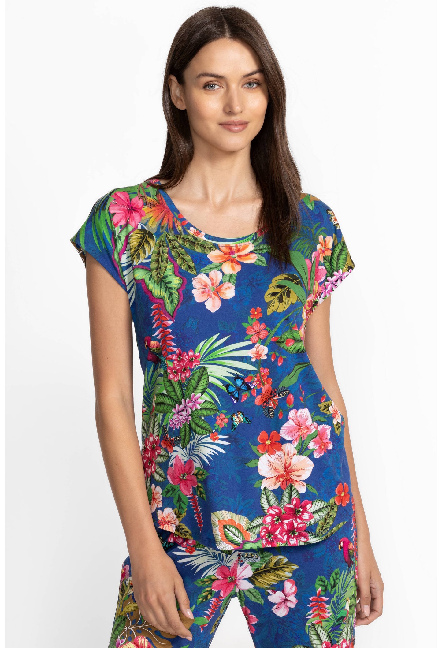 Woman wearing a colorful tropical floral pajamas on a white background